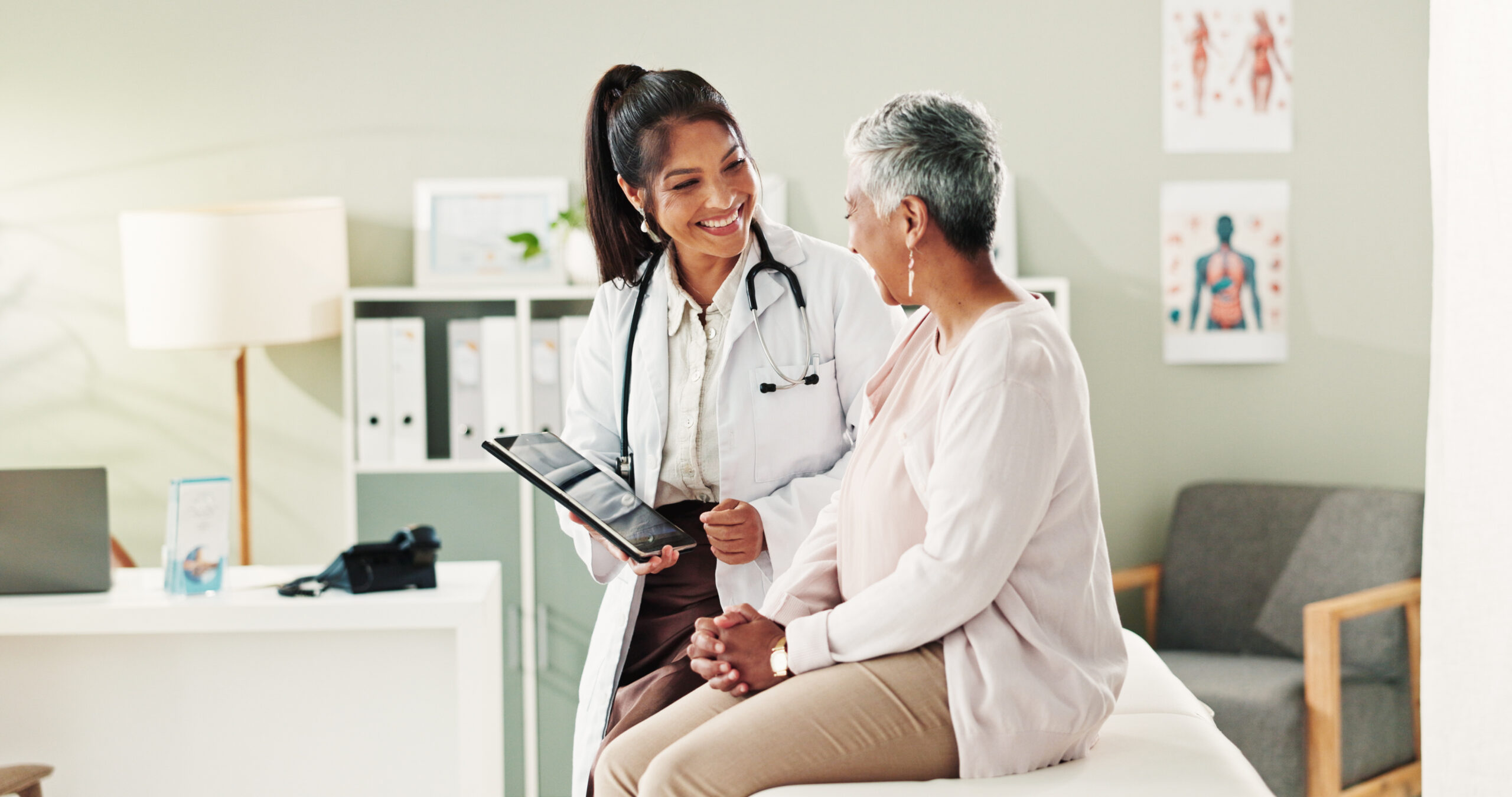 Mature patient, doctor and tablet for healthcare, support or conversation with checkup appointment in office. Female person, medical professional and diagnosis talk for senior woman at clinic.